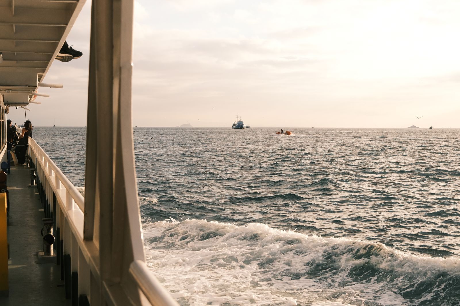 Sunset over the open sea from a ship promenade deck, the view people picture when they search how to get a free cruise