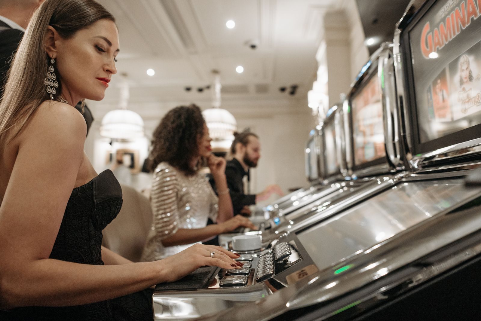 Women playing slot machines in an elegant casino, the kind of play that can lead to a free cruise offer